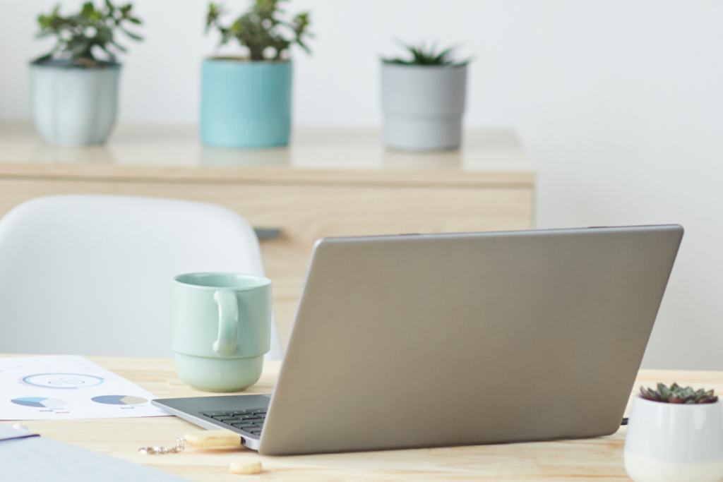 A calm, softly lit desk with a laptop, notebook, and coffee mug, suggesting a peaceful atmosphere for writing a therapist's newsletter.